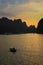 Sunset on Ha long bay with back lit rowing boat