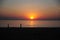 Sunset on the indian ocean, evening sky in red and orange colors. Silhouettes of people against the sea and setting sun. Twilight