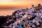 Sunset at the Island Of Santorini Greece, beautiful whitewashed village Oia with church and windmill during sunset