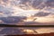 Sunset on the lake. Beautiful sunset behind the storm clouds before a thunder storm above the over lake landscape background.