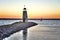 Sunset on Lake Hefner in Oklahoma City, lighthouse in the foreground and a lone sail boat on the water