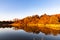 Sunset on the Lake; lakeshore beautiful skyline with fall foliage colors and reflections in the lake