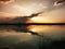 Sunset at lake, storm clouds reflected on the surface of the water