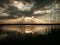 Sunset at lake, storm clouds reflected on the surface of the water