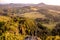 Sunset landscape with hills, sandstones, forest and village.