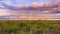 Sunset landscape of the marshes of south San Francisco bay, Mission Peak covered in sunset colored clouds, Sunnyvale, California