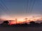 Sunset landscape nature scenery with electric posts with lines .