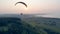 Sunset landscape and a person flying the paraplane