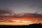 Sunset landscape, silhouettes of trees against an orange intense bright sky