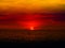 sunset last light of sun on horizontal line over orange sky