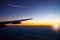 Sunset and lens flare in twilight time with wing of an airplane and cloud sky. Photo applied to tourism operators background