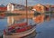 Sunset light at harbor and pier of Svolvaer with view to hotels in traditional wooden architecture and historic boat