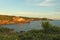 Sunset light on the hillside wall and the bright blue sky over the sea background. Tranquil beach landscape backgrounds