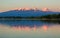 Sunset lighting Kluchevskaya group of volcanoes with reflection in river Kamchatka.