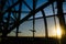 Sunset lights shining through the Sydney Harbour bridge structure.