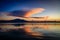 Sunset lights up a large cloud over a mountain top reflecting on Lake Chapala in Ajijic Mexico