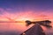 Sunset on Maldives island, luxury water villas resort and wooden pier. Beautiful sky and clouds and beach background