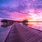 Sunset on Maldives island, luxury water villas resort and wooden pier. Beautiful sky and clouds and luxury beach background