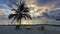 Sunset in the Maldives. There are two sun loungers on the sandy beach.