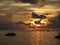 Sunset on the Maldives with a view of the bay with boats and a small motor plane.