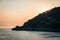 Sunset on Mediterranean sea, small chapel on the rocks, Madonnina della Punta, Bonassola, Liguria, Italy