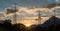 Sunset in a mountain landscape with electrical power lines and masts in the foreground