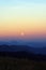 Sunset on the mountains in a full moon evening