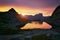 Sunset in mountains near lake. Sunlight reflected on mountain tops. Golden light from sky reflected in a mountain lake. Ergaki.