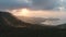 Sunset, mountains silhouette aerial: Thailand zooming shot. Forest in sun rays light at cloudy sky