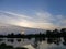 Sunset in nature, the river, the shore in the green, clouds.