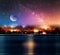 Sunset  at night ,starry sky nebula and big moon on sea on horizon city light blurred light 3 d illustration