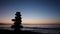 Sunset at ocean / beach with stacked stones silhouette