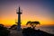 Sunset in Onna Son, Okinawa, Japan, with a calm sea and a glow from the setting sun. A silhouette of a lighthouse.