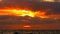 Sunset orange sky and dark red cloud moving on sea little wave of water reflection sunlight