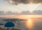 Sunset over aegean sea with view to Virgin Mary Catholic Church Three Bells of Fira, Santorini.