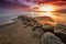 Sunset over a beach with large rocks