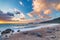 Sunset over beautiful beach and water bay in the greek spectacular coast line. Waving sea unique sky, Greece summer top travel