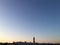 Sunset over the big city. Roofs of high-rise buildings. Pipe on a background of clear sky. Panorama.