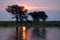 Sunset over the Chobe River with people camping on the bank