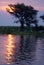 Sunset over the Chobe River with people camping on the bank