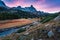 Sunset over Claree Valley with Main De Crepin peak and river flow through in larch forest during autumn at French Alps, France