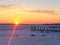 Sunset over frozen lake and broken docks