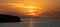 Sunset over Greek island, Cyclades, Greece. Golden sun hides behind cloud. Sparkle sea. Banner