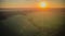 sunset over a green field and a lake. aero photo