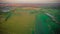 sunset over a green field and a lake. aero photo