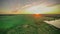 sunset over a green field and a lake. aero photo