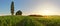 Sunset over green wheat field with path and chapel in Slovakia -