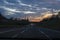 Sunset over the highway full of cars across the bridge and sky full of clouds. Journey, adventurous concept