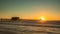 Sunset over horizon and wooden pier of caribbean beach of Naples in Florida