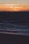 Sunset over the Indian Ocean in City Beach in Perth with silhouettes of swimmers and surfers in the ocean water